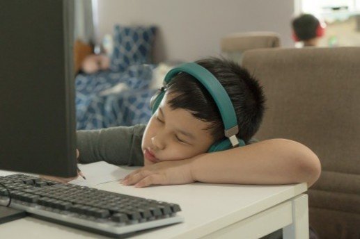 tired_asian_school_boy_fall_asleep_during_online_learning_course_boring_homeschooling_during_s...jpg