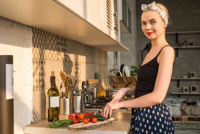 beautiful-girl-in-the-image-of-pin-up-cuts-vegetables-in-the-kitchen-400-178221036.jpg