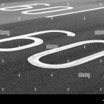 60-km-pro-stunde-tempolimit-fahrbahnmarkierung-auf-dunkelgrau-asphalt-p8e2d8.jpg